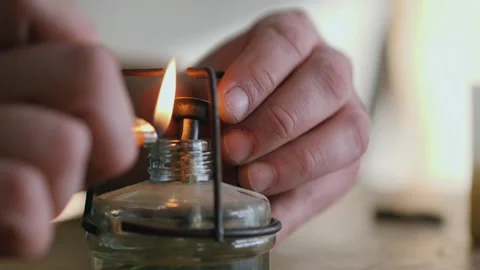 A man lights an alcohol burner with a lighter Stock Footage 146574283