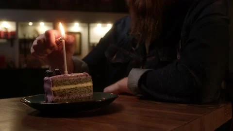 A man lights a candle in a cake Stock Footage 223881848