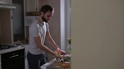 Man lights candles and picks up a breakfast tray prepared with tea, croissant 库存影片 330128682
