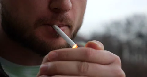 Man Lights a Cigarette Outside with a Cigarette Lighter Stock Footage 231020500