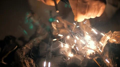 Man lights a fire in the dark with a sparkling flint. Stock Footage 151647759