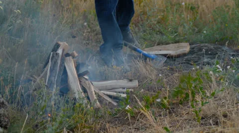 A man lights the fire, the fire on the nature Stock Footage 27069886
