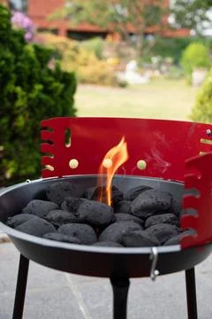 A man lights a fire with a lighter special charcoals for a barbecue Stock Photos