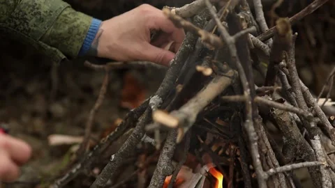 Man lights a fire with a tree bark Stock Footage 93540180