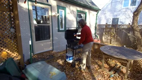 A man lights his BBQ 4K wide shot Stock Footage 142276805