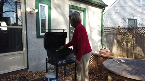 A man lights his BBQ medium shot 4K Stock Footage 142276890