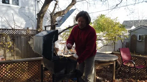 A man lights his BBQ medium shot 4K Stock Footage 142277095