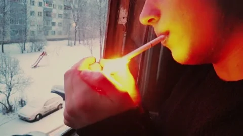 The man lights his cigarette and blows smoke out the window. Stock Footage 147148090