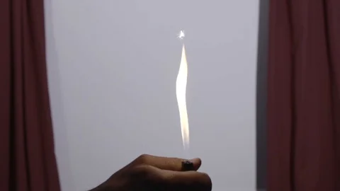 Man lights large flame with cigarette lighter in room, close-up Stockbeeldmateriaal 106120778