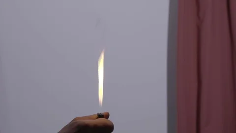 Man lights large flame with cigarette lighter in room, close-up Stock Footage 106120846