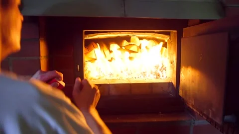 Man Lights a Large Stove Full of Firewood by Igniting Wood Chips. Stock Footage 306401015