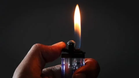 A man lights a lighter Stock Footage 335679709