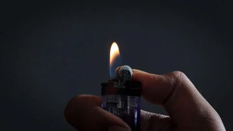A man lights a lighter Stock Footage 335679718