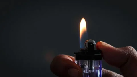 A man lights a lighter Stock Footage 335679719
