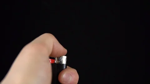 A man lights a lighter. A man holds a lighter in his hand and spins a drum on a Stock Footage 123313490