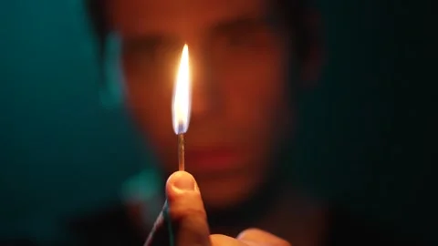 A man lights a match in the dark Stock Footage 312473974