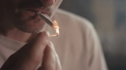 Man lights up a match fire rolled tobacco cigarette smoke it close up Stock Footage 147250563