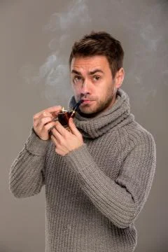 Man lights a pipe Stock Photos