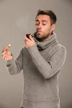 Man lights a pipe Stock Photos