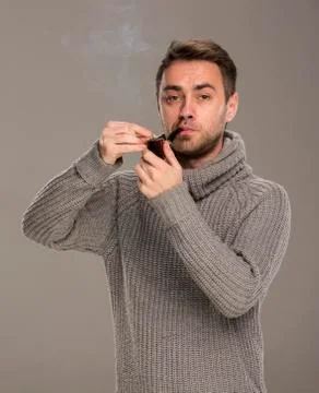 Man lights a pipe Stock Photos