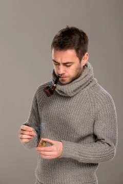 Man lights a pipe Stock Photos