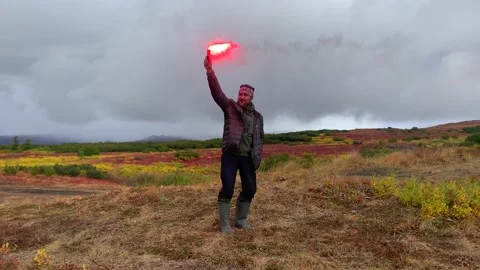 A man lights a signal fire in a field Vídeos de archivo 140085992