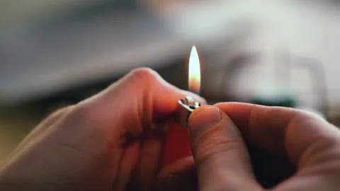 A man lights a string with a lighter to connect the two ends Stock Footage 146574835