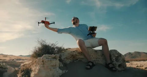 Man in linen shirt flying drone in deserted sandy landscape, 120 fps slow-m Stock Footage 296000153