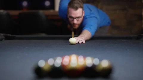 Man lining up a billiards shot on a pool table, with cue ball in focus, blurred Stock Footage 341048716