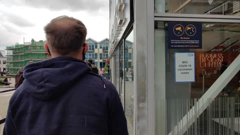 MAN LINING UP TO GET HIS COVID VACCINE AT A CENTRE IN LONDON UK 4K Stock Footage 154552755
