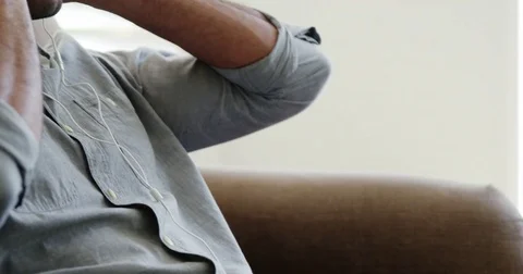 Man listening music in living room Stock Footage
