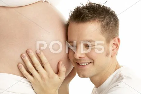 Man Listening To Pregnant Woman's Stomach Stock Photos