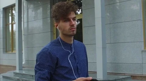 Man listens to music walking down the street Stock Footage 68593217