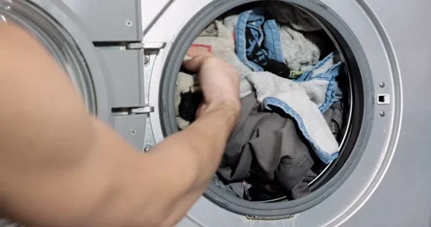Man load dirty things in an automatic washing machine. Stock Footage 166936751