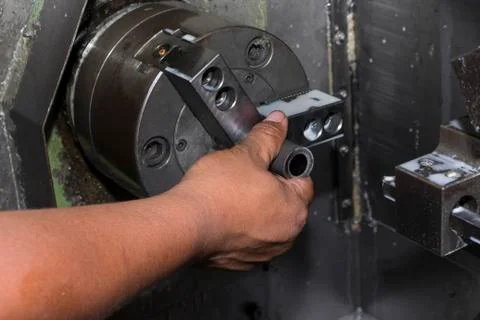 Man load workpiece into lathe machine Stock Photos