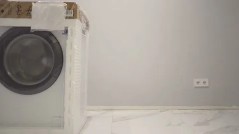 Man loader moves the washing machine to be installed in the bathroom Stock Footage 150058477