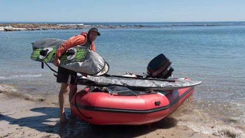Man loading boards onto small boat Stock Photos