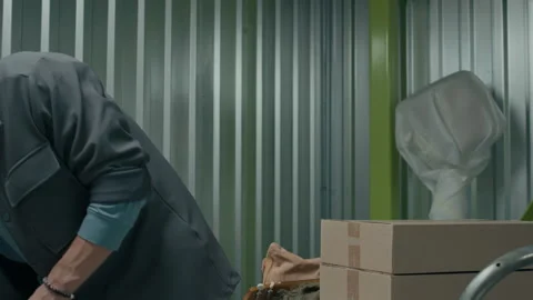 Man Loading Boxes and Containers on Cart Inside of Self Storage Unit Video stock 290780539