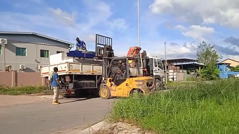 Man loading building materials with forklift assisted by two people Stock Footage 304610392
