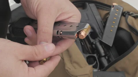 Man Loading Bullets Into a Pistol Magazine Stock Footage 60665775
