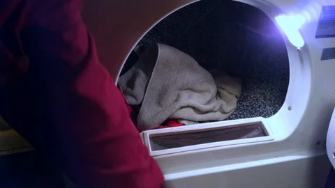 Man Loading Clothes Dryer Stock Footage 101964192