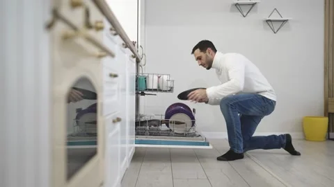 Man Loading Dishes into Dishwasher During Home Kitchen Chores and Spring Vidéo 329021596