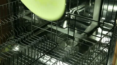 Man loading the dishwasher with plates and a glass dish Stock Footage 22322824