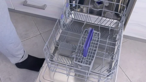 Man loading dishwasher putting tableware and kitchenware in basket, high speed. Stock Footage 116857360