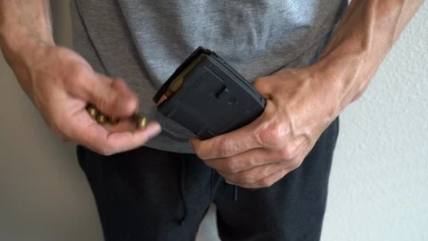 Man loading an extended capacity AR-15 assault weapon magazine with bullets Video stock 114105357
