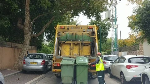 A man loading garbage cans to garbage truck Stockbeeldmateriaal 100066634