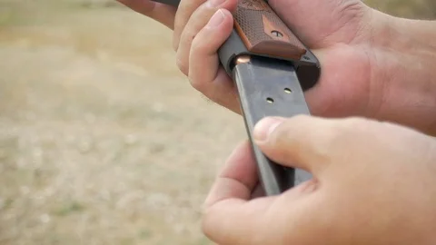 Man Loading Handgun with Ammo Clip Practicing Gun Control in Slow Motion Stock Footage 87847650