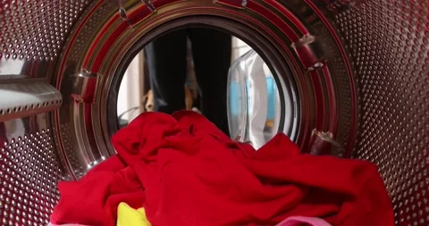 Man is loading laundry in washing machine. View from inside. The man goes to  Stock Footage 152856381