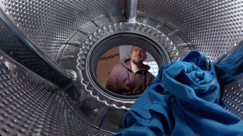 Man Loading Laundry into Washing Machine, View from Inside Drum Stock Footage 332907536