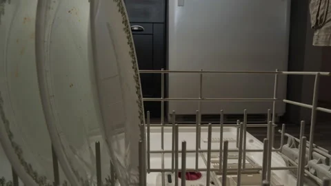 A man loading plates into a dishwasher Stock Footage 202040953